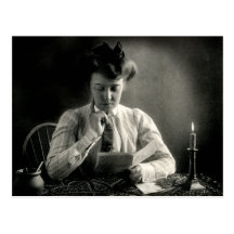 1902 que lee por luz de una vela tarjetas postales