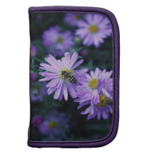 Abeja de la miel en la flor púrpura brillante planificador