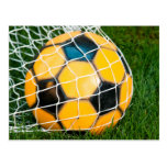 Balón de fútbol amarillo y negro en red tarjeta postal