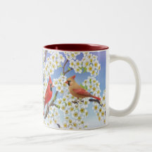 Cardenales en el florecimiento de la taza del manz