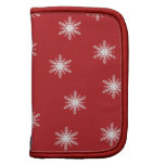 Copos de nieve en folio rojo del carrito planificadores