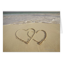 Dos corazones sobrepuestos dibujados en la playa felicitaciones