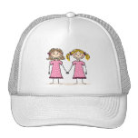 Dos niñas que llevan a cabo las manos gorros  