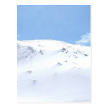 Esquí en las montañas en nieve postal