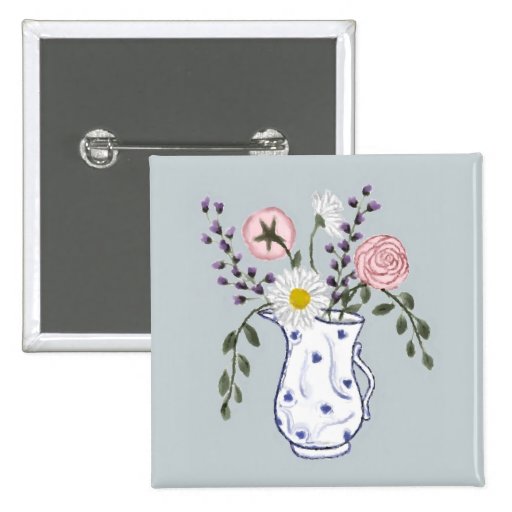 Flores en un botón azul y blanco del jarro pins