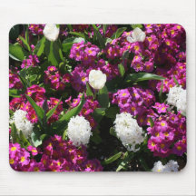 Flores mezcladas de la primavera en cama de flor alfombrillas de raton