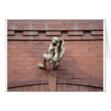 Gargoyle que cuelga en la pared de ladrillo roja felicitaciones