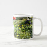 Gato al lado de los tulipanes rojos en el jardín tazas de café