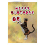 Gato juguetón y 88.os globos del feliz cumpleaños felicitación