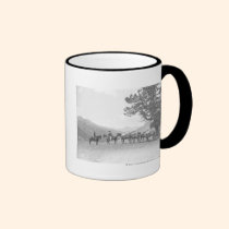 Hombres con los packhorses que miran sobre una col tazas
