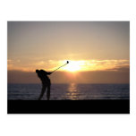Jugar a golf en la puesta del sol postal