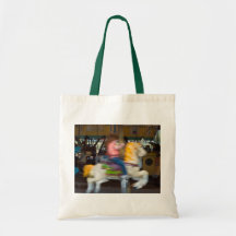 La bolsa de asas con el niño en un carrusel