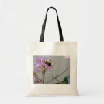Minúsculo manosee la abeja que recoge la miel y el bolsa de mano