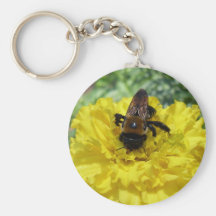 Minúsculo manosee la abeja que recoge la miel y el llaveros