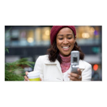 Mujer de negocios sonriente con el teléfono celula tarjetas de negocios