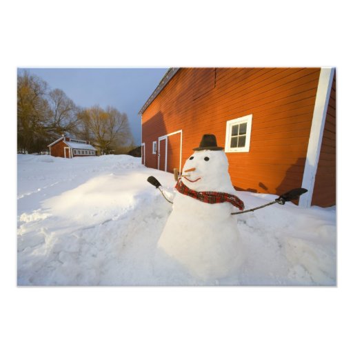 Muñeco de nieve delante del granero rojo en las ca fotografias