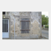 Pared de piedra vieja con una puerta y una ventana rectangular altavoz