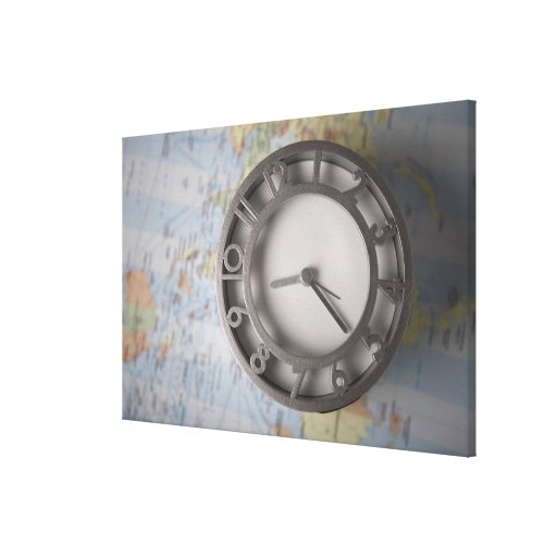 Primer de un reloj delante de un mapa lienzo envuelto para galerias