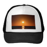 Puesta del sol anaranjado oscuro con la reflexión  gorro de camionero