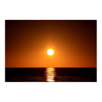 Puesta del sol anaranjado oscuro con la reflexión  posters