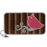 Puntos del chocolate y pájaro rosado en una rama e altavoces de viaje