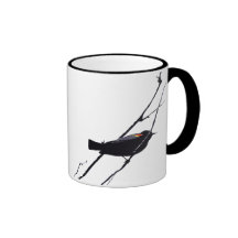 Taza negra de alas rojas del pájaro