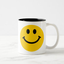 Taza sonriente feliz amarilla de la cara