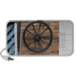 Una rueda vieja del carro en una pared de ladrillo iPod altavoces
