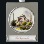 Adorno Con Rótulo Plateado El ornamento de pintura de la acuarela de Santa So<br><div class="desc">¿Sueño con vivir o visitar Turquía? ¿Quieres conmemorar tus viajes allí? ¡Te tenemos! Este adorable adorno exhibe hermosas acuarelas de la iglesia de Santa Sofía. Busque otras áreas populares del mundo y monumentos en la tienda Paws Charming. Hermoso regalo para los amantes de todo viaje. ¡Eğlence (Disfruten)!</div>