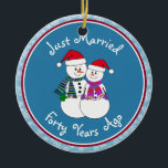 Adorno De Cerámica 40 Aniversario Regalo Navidades de parejas de niev<br><div class="desc">Nuestra pareja festiva de nevados está vestida para el frío con sus pañuelos estampados, mitones coordinadores y sombrero de Santa Festividad roja. Divertido mensaje de "Solo casado" sin importar cuánto tiempo se hayan casado sus familiares o amigos de celebración. Añada sus nombres y la fecha del año del aniversario para...</div>