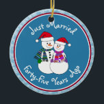 Adorno De Cerámica 45° Aniversario Regalo Navidades de parejas de nie<br><div class="desc">Nuestra pareja festiva de nevados está vestida para el frío con sus pañuelos estampados, mitones coordinadores y sombrero de Santa Festividad roja. Divertido mensaje de "Solo casado" sin importar cuánto tiempo se hayan casado sus familiares o amigos de celebración. Añada sus nombres y la fecha del año del aniversario para...</div>