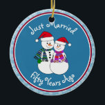 Adorno De Cerámica 50° Aniversario Regalo Navidades de parejas de nie<br><div class="desc">Nuestra pareja festiva de nevados está vestida para el frío con sus pañuelos estampados, mitones coordinadores y sombrero de Santa Festividad roja. Divertido mensaje de "Solo casado" sin importar cuánto tiempo se hayan casado sus familiares o amigos de celebración. Añada sus nombres y la fecha del año del aniversario para...</div>