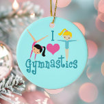 Adorno De Cerámica Amo la Gimnasia<br><div class="desc">Me Encanta La Gimnasia. Un regalo chica de gimnasia de bonito con un adorable texto verde azulado entre dos lindas niñas tambaleantes y un hermoso corazón rosado. Un lindo regalo de gimnasta para un entrenador de gimnasia infantil o femenino. Una morena en un atril y un chica rubio con los...</div>