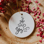 Adorno De Cerámica Árbol De Navidad En El Que Dijo Sí.<br><div class="desc">Este adorno navideño "ella dijo que sí" es la perfecta decoración romántica de los árboles de navidad. El diseño presenta un anillo de diamantes,  y las palabras "ella dijo que sí" con el año y un corazón pequeño dispuestos a parecerse a un árbol de navidad.</div>