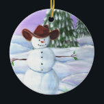 Adorno De Cerámica Cowboy Snowman<br><div class="desc">El cowboy Snowman ilustró la imagen. Usa un gorra de vaquero marrón,  se sienta en rollos de nieve con pinos y puesta de sol morada en el fondo.</div>