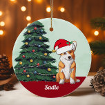 Adorno De Cerámica Cute Corgi Santa Hat Monogramado Árbol de Navidad<br><div class="desc">Este hermoso perro de Pembroke Welsh Corgi tiene un lindo gorra de Santa Claus y una adorable inclinación de la cabeza. El cachorro tricolor está sentado frente a un árbol de Navidad bonito decorado con adornos coloridos. Personaliza tu nombre de mascota en una cursiva encantadora bajo el maravilloso dibujo de...</div>