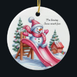 Adorno De Cerámica Deliciosa diversión en el patio de recreo rosa de<br><div class="desc">Un encantador muñeco de nieve vestido con accesorios rosas en un tobogán rosa brillante. Árboles de Navidad con decoraciones en el fondo nevado. El mensaje dice: "Me divierto mucho con la nieve. Añade este adorno a tu decoración de Navidades rosados.</div>
