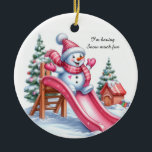 Adorno De Cerámica Deliciosa diversión en el patio de recreo rosa de<br><div class="desc">Un encantador muñeco de nieve vestido con accesorios rosas en un tobogán rosa brillante. Árboles de Navidad con decoraciones en el fondo nevado. El mensaje dice: "Me divierto mucho con la nieve. Añade este adorno a tu decoración de Navidades rosados.</div>