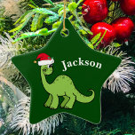 Adorno De Cerámica Dinosaurio infantil de Navidades verdes<br><div class="desc">Impresionante dinosaurio verde sonriendo y luciendo muy lindo en un festividad de sombrero rojo de Santa. Me gustan los animales de Navidades prehistóricos y los regalos que los niños amarán. Personalizar este regalo con el nombre del destinatario para hacerlo aún más personalizado.</div>