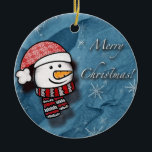 Adorno De Cerámica Feliz Navidad, hombre de nieve con ropa de punto<br><div class="desc">Un pequeño y hermoso muñeco de nieve con ropa de punto blanco y rojo en un papel azul. Perfecto para desear feliz Navidad a los más pequeños.</div>