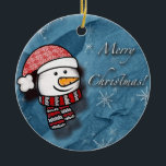 Adorno De Cerámica Feliz Navidad, hombre de nieve con ropa de punto<br><div class="desc">Un pequeño y hermoso muñeco de nieve con ropa de punto blanco y rojo en un papel azul. Perfecto para desear feliz Navidad a los más pequeños.</div>