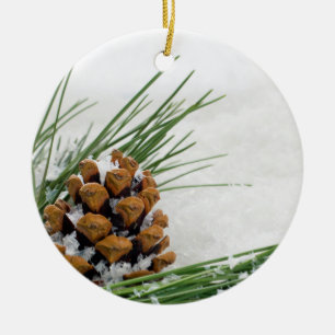 Adorno De Cerámica Fir Cone con la nieve lanzada alrededor de un ador