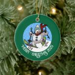 Adorno De Cerámica Gracioso Snowman Feliz Navidad Añade el año Person<br><div class="desc">Un divertido ornamento de snowman esquiando para tu árbol de Navidad. Utilice "Personalizar esta plantilla" para modificar el texto o el año y hacer un regalo único personalizado de Navidad. La decoración de los árboles muestra un caprichoso personalizado de un exaltado muñeco de nieve con la nariz de zanahoria, cayendo...</div>