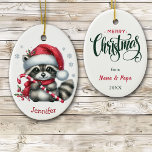 Adorno De Cerámica Navidades de Cute Santa Hat Raccoon<br><div class="desc">Delante de este adorable adorno navideño infantil hay un adorable mapache que sostiene un bastón de caramelo. Lleva un sombrero de Santa Claus rojo y blanco y una bufanda. Hay algunos copos de nieve de plata dispersos, y tu nombre personalizado está en la parte inferior. La parte trasera del adorno...</div>