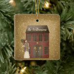 Adorno De Cerámica Navidades de país primitivo Nombre personalizado d<br><div class="desc">Una casa de campo roja y primitiva de salero se encuentra en la nieve que cae con un adorable y primitivo hombre de nieve. La casa de salazón roja tiene primitivas estrellas doradas en las puertas y está personalizada con el nombre de tu familia. Qué divertido añadido a tu árbol...</div>