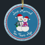 Adorno De Cerámica navidades de parejas de nieve divertida en regalo<br><div class="desc">Nuestra pareja festiva de nevados está vestida para el frío con sus pañuelos estampados, mitones coordinadores y sombrero de Santa Festividad roja. Divertido mensaje de "Solo casado" sin importar cuánto tiempo se hayan casado sus familiares o amigos de celebración. Añada sus nombres y la fecha del año del aniversario para...</div>
