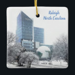 Adorno De Cerámica Navidades Raleigh NC Science Museum Globe<br><div class="desc">Este adorno navideño de Raleigh, NC, presenta una hermosa imagen nevada del mundo en el Museo de Ciencias Naturales y el edificio de la Unión de Crédito de Empleados del Estado. La redacción del ornamento, así como el tipo de letra y el color del texto, pueden modificarse o suprimirse para...</div>