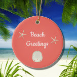 Adorno De Cerámica Navidades Sea Shell Beach Pink<br><div class="desc">Beach Greetings con concha marina adorno navideño de Navidad. Con una concha de vieiras con acentos rojos y rosados,  esta pieza tiene un fondo de melocotón rosado. Con letras blancas,  puedes personalizar con tu propio texto. ¡Ideal para decorar tu árbol de vacaciones en la playa!</div>