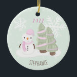 Adorno De Cerámica Navidades Snowman<br><div class="desc">Navidades de Snowman celebran el cumpleaños de su hijo en invierno con este lindo y muñeco de nieve usando un gorra de punto rosa pastel y bufanda. Este tema es ideal para los Navidades de invierno o para los fiestas. El diseño es completamente personalizable. Consulte la papelería de coordinación y...</div>