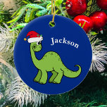 Adorno De Cerámica Niños Personalizados de dinosaurios Navidades boni<br><div class="desc">Impresionante dinosaurio verde sonriendo y luciendo muy lindo en un gorra de vacaciones de Santa Claus rojo. Personalizar este adorable regalo de adorable ornamento de Navidad para niños con el nombre del destinatario para hacerlo aún más personalizado. Niño de Guay presente para un niño.</div>